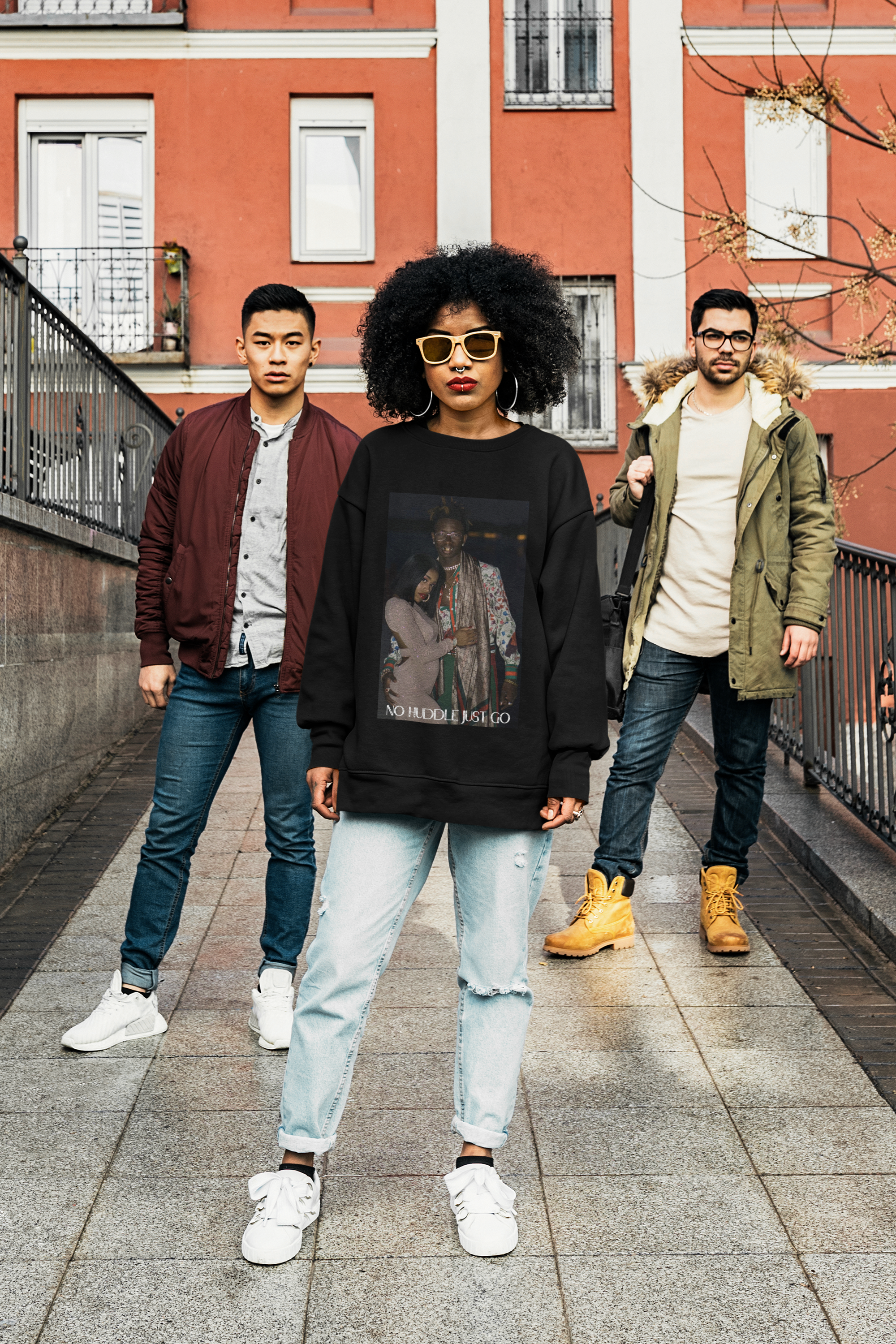 Curly haired model wearing black signature sweatshirt, featuring signature‘No Huddle, a premium essential for any wardrobe.